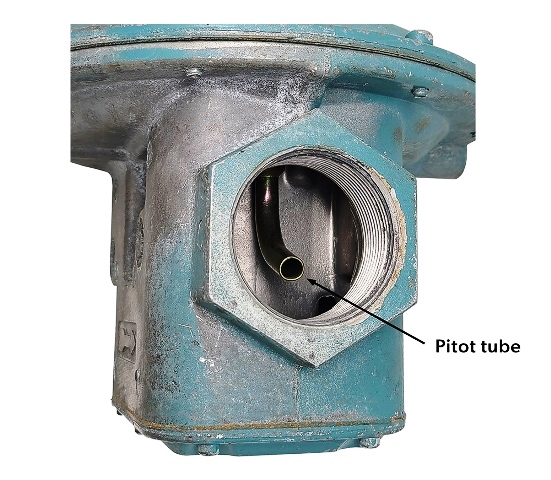 Image of a regulator, highlighting the pitot tube. It is a small, curved tube that is seen through the exit of the valve body.